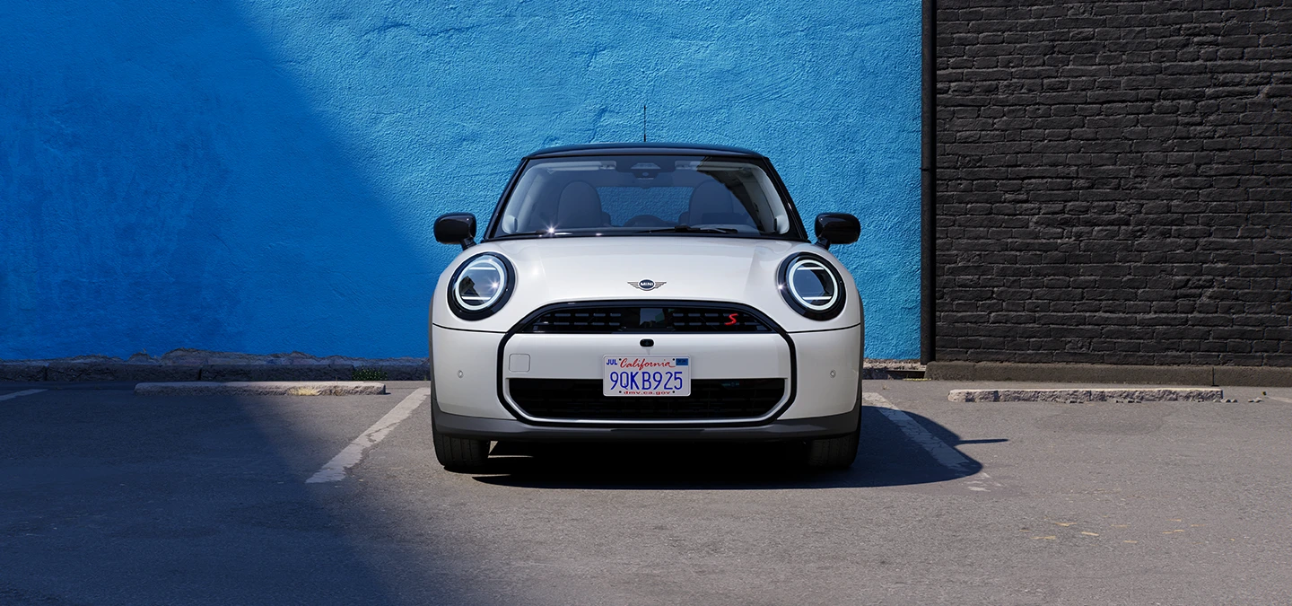 Front view of the MINI Cooper in Nanuq White with Black Roof parking.